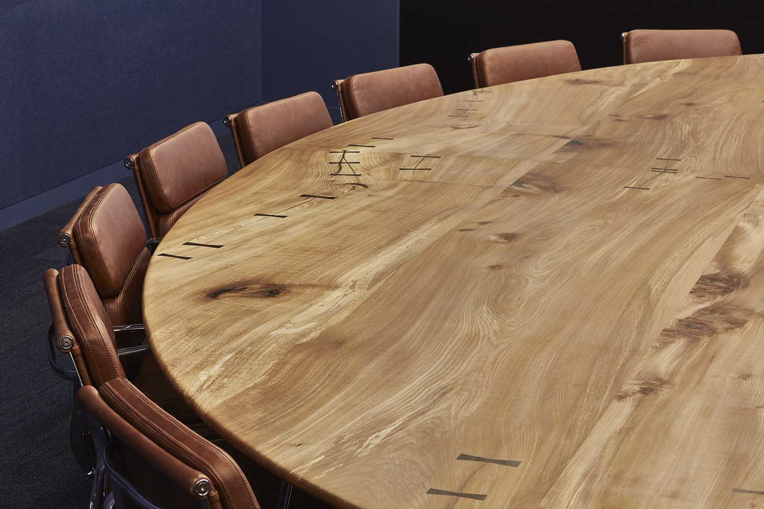 Bespoke eliptical boardroom table made from solid elm with bog oak butterfly ties