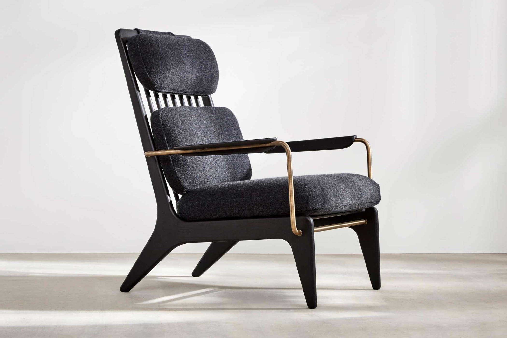 black high-backed chair with black wool upholstery and brass arms