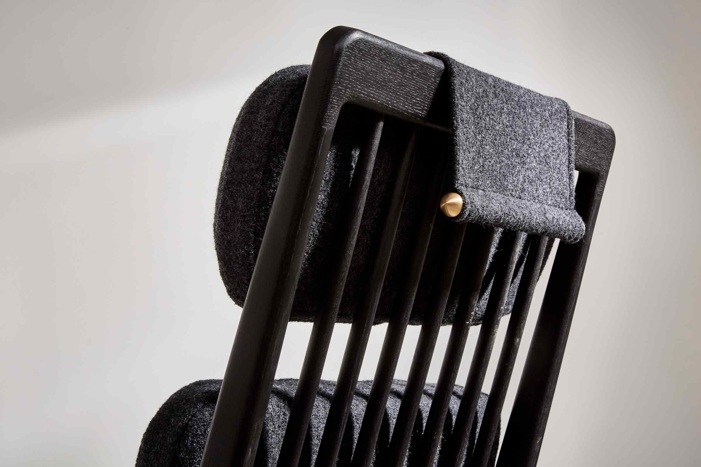 black high-backed chair with black wool upholstery and brass arms