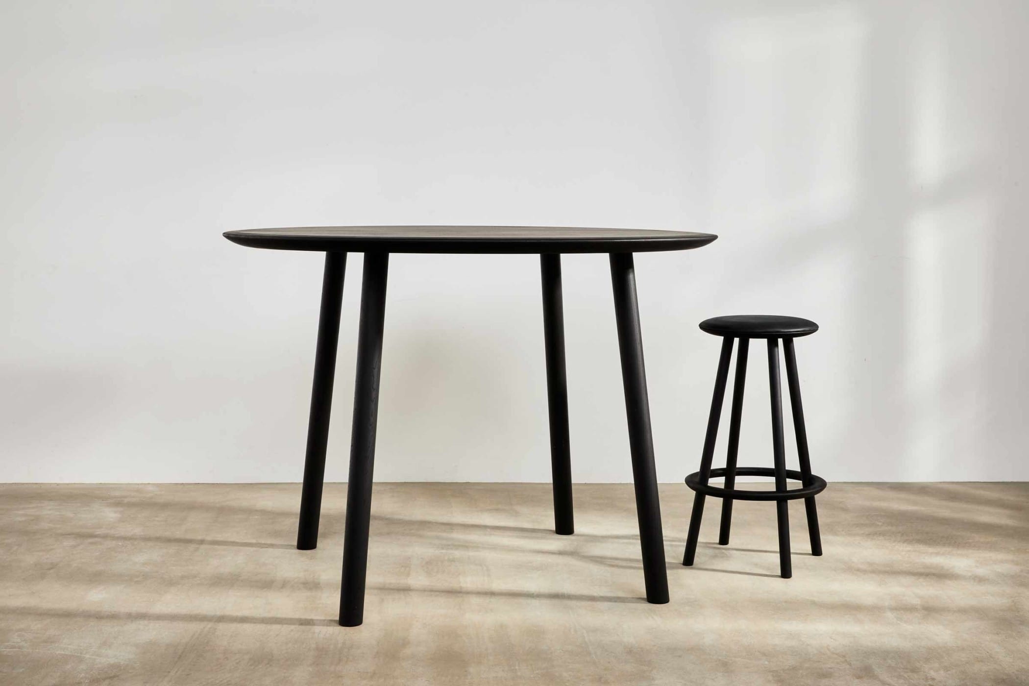 black ebonised table with a black bar stool