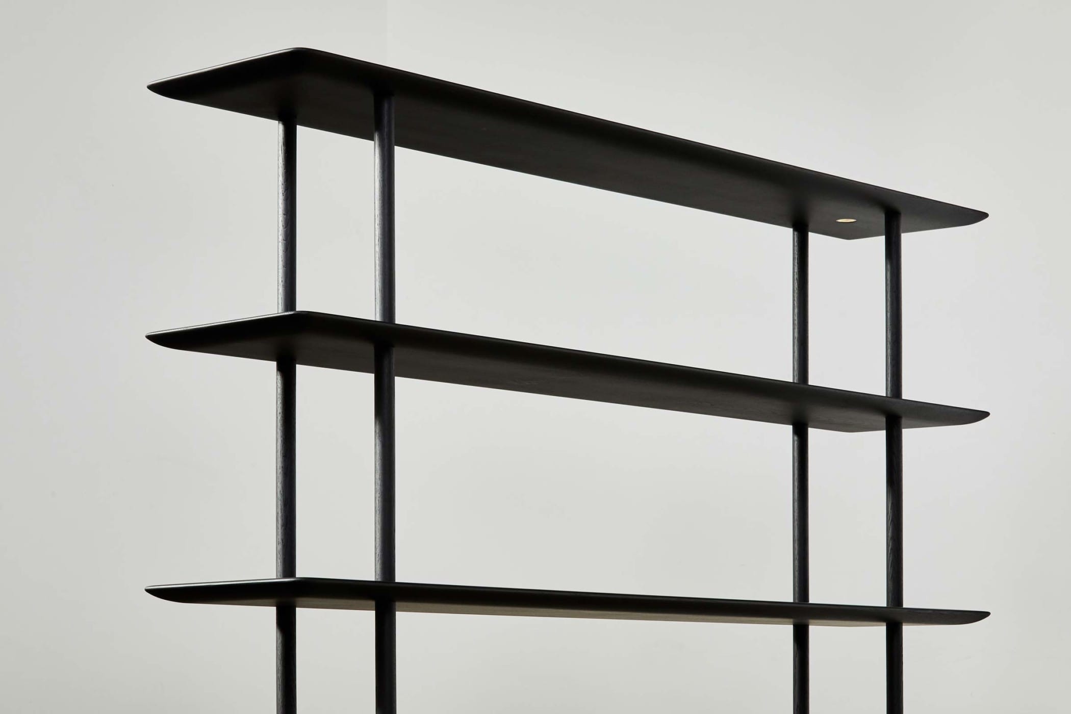 close up of three of five ebonised oak shelves